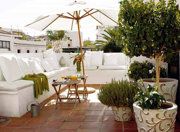 terraza-exterior-con-banco-perimetral-cojines-y-sombrilla